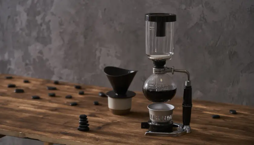 Kawiarka syfonowa i dripper na drewnianym blacie. Dowiedz się, jak długo parzyć kawę sypaną, by uzyskać idealny smak.
