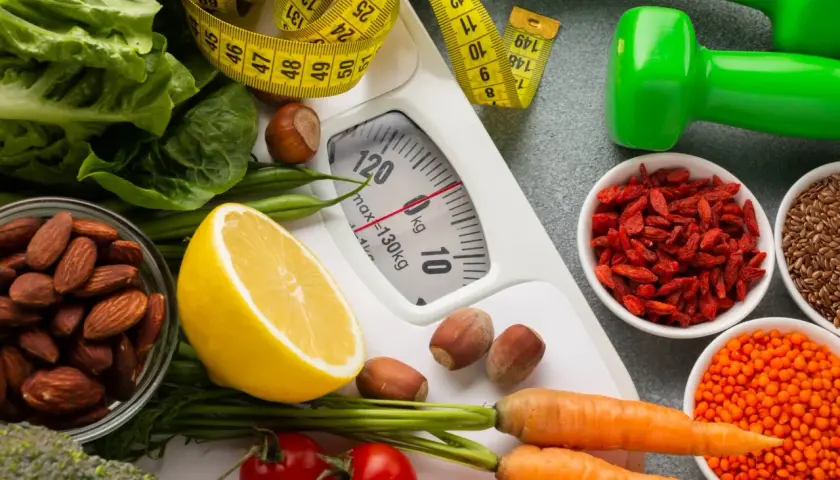 Zdrowa dieta i ćwiczenia to klucz do tego, jak przyspieszyć metabolizm. Waga, miarka, warzywa, orzechy i nasiona.