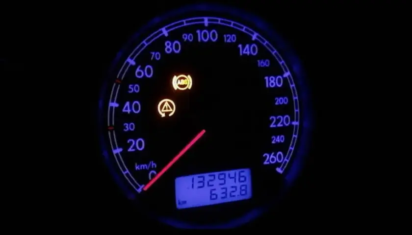 Tablero de coche con luces de advertencia de ABS y fallo encendidas. El velocímetro muestra 0 km/h.