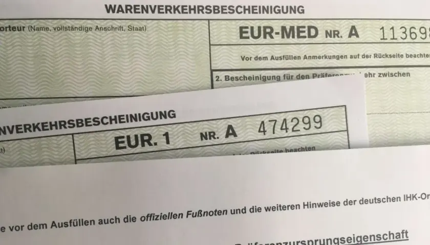 Zwei Warenverkehrsbescheinigungen, eine mit "EUR-MED" und eine mit "EUR. 1", sind übereinander gelegt.