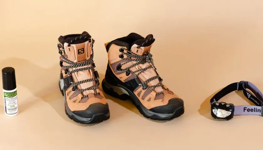 Hiking boots, insect repellent, and a headlamp are laid out. When choosing wanderschuhe worauf achten? Comfort and durability are key for any adventure.