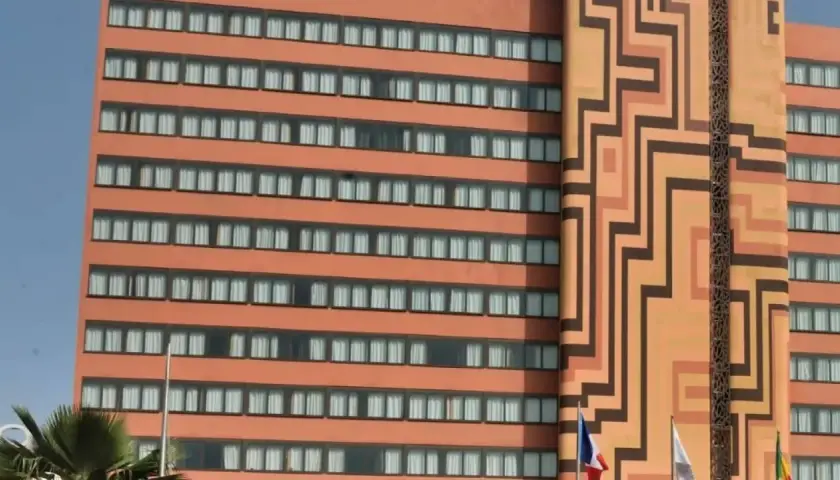 Façade d'un hôtel orange avec des motifs géométriques et des fenêtres.