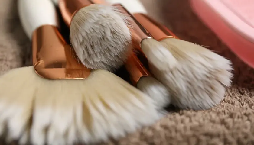 Set de brochas de maquillaje con mangos blancos y detalles dorados, listas para aprender como limpiar brochas de maquillaje.