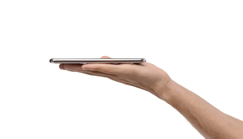 Dłoń trzyma cienki, srebrny smartfon. Może to być nowy model, np. kierunkowy 95 Polska.