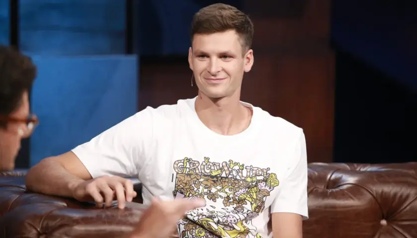 Uśmiechnięty Hubert Hurkacz, zapytany ile ma lat, siedzi na kanapie w studiu.