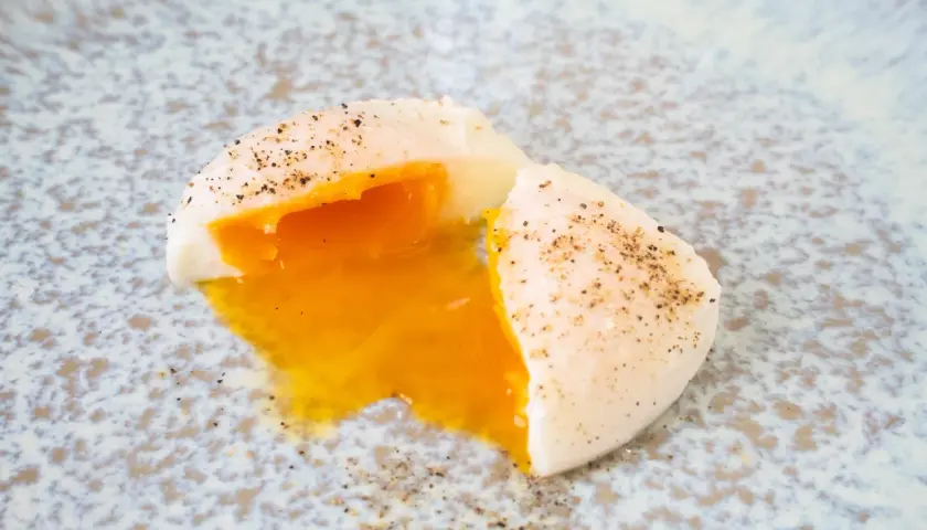 Perfekt pochiertes Ei mit flüssigem Eigelb, bestreut mit Pfeffer. Ein einfaches pochierte eier rezept für jeden Tag.