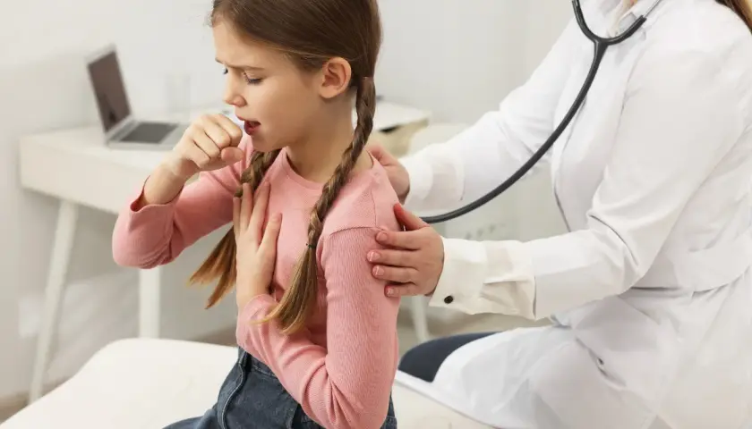 Bambina con tosse notturna, tossisce mentre il medico la ascolta con lo stetoscopio.
