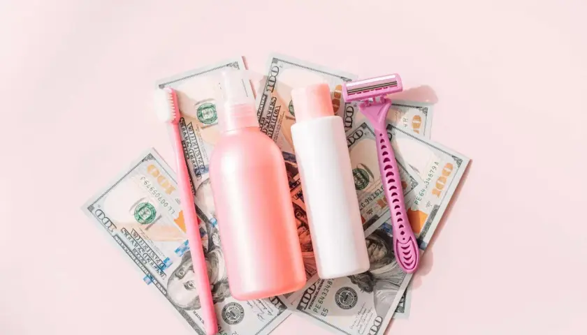 Rosa Rasierer, Zahnbürste und Kosmetikflaschen auf 100-Dollar-Scheinen. Ein Symbol für den "Pink Tax", der Frauen mehr kostet.