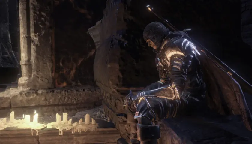 Rycerz w zbroi siedzi przy świecach, szukając wskazówek w mrocznym świecie. To może być kluczowy moment w twoim **dark souls poradnik**.