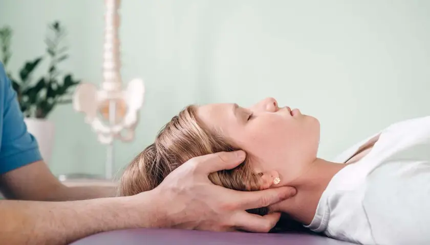 Delikatna terapia cranio sacralna u młodej dziewczyny. Terapeuta delikatnie uciska jej głowę, wspierając proces leczenia.