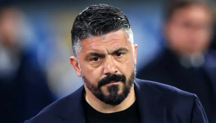 Gennaro Gattuso, zamyślony trener w granatowej marynarce, z charakterystyczną brodą i siwiejącymi włosami.
