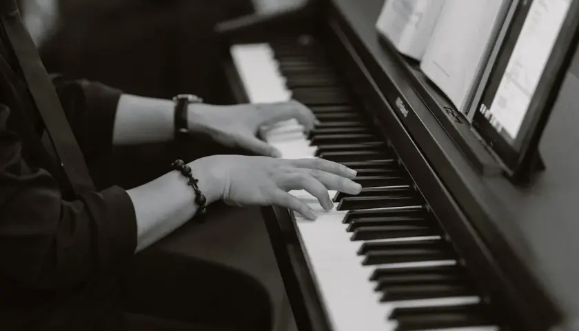 Dłonie grające na pianinie, w eleganckim stroju, tworzą niepowtarzalny styl w jazie.