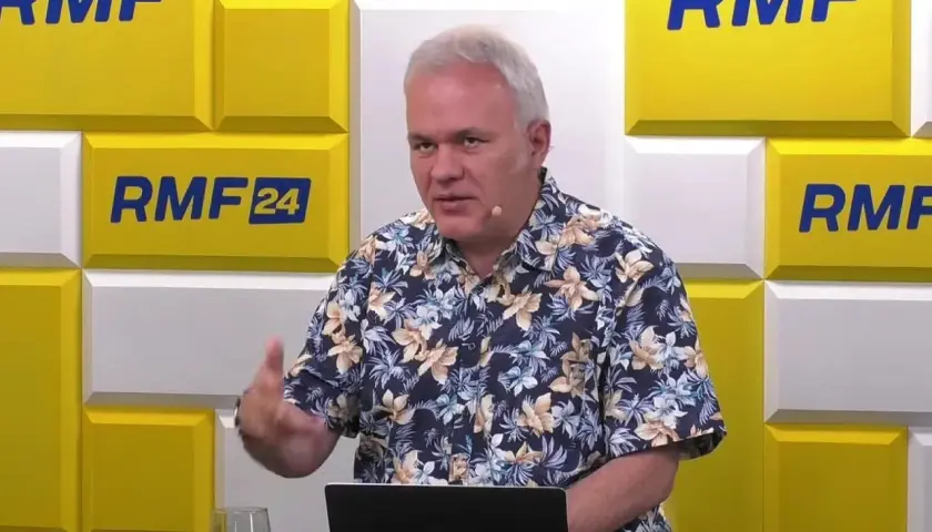 Mazurek z RMF FM w hawajskiej koszuli gestykuluje podczas rozmowy.