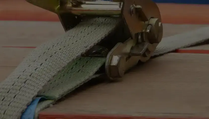 Spanngurt sichert Transportgut auf Ladefläche. Robuste Ratsche hält die Fracht sicher.