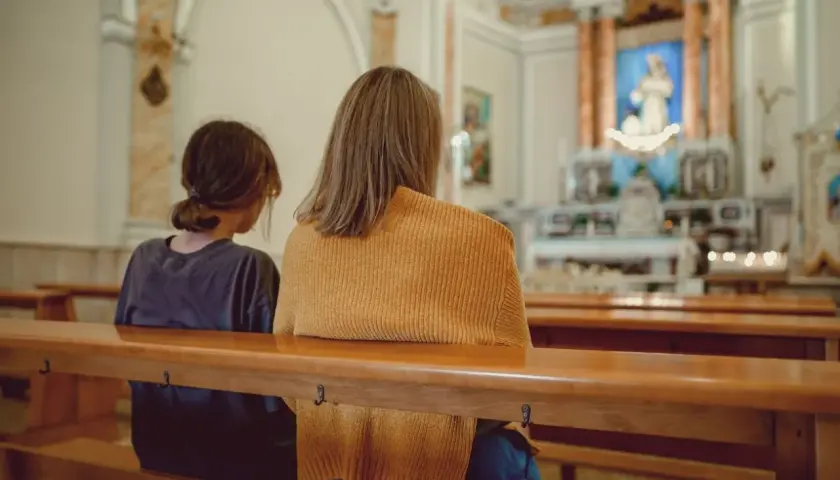 Dwie osoby siedzą w kościele, zastanawiając się, kto może zostać świadkiem bierzmowania.