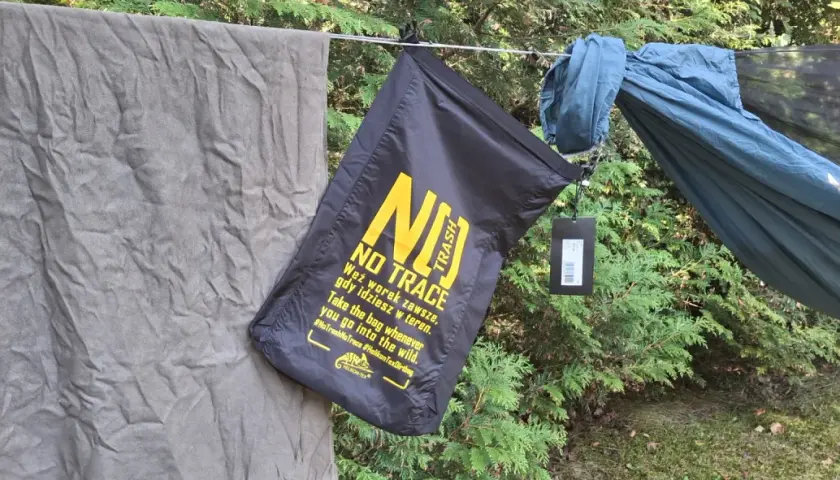 Czarny worek na śmieci z napisem "NO TRACE" przypomina o zasadach "leave no trace" podczas wypoczynku na łonie natury.