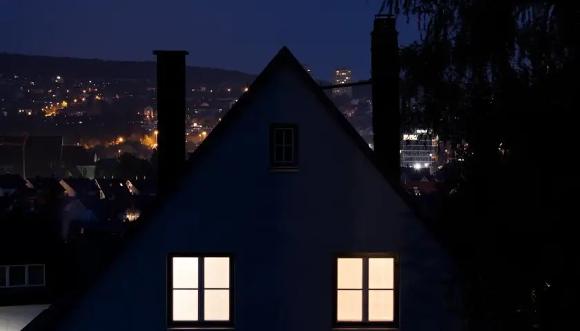 Nocny krajobraz miasta z oświetlonymi domami i budynkami. Immisja światła z miasta tworzy ciepłą poświatę.