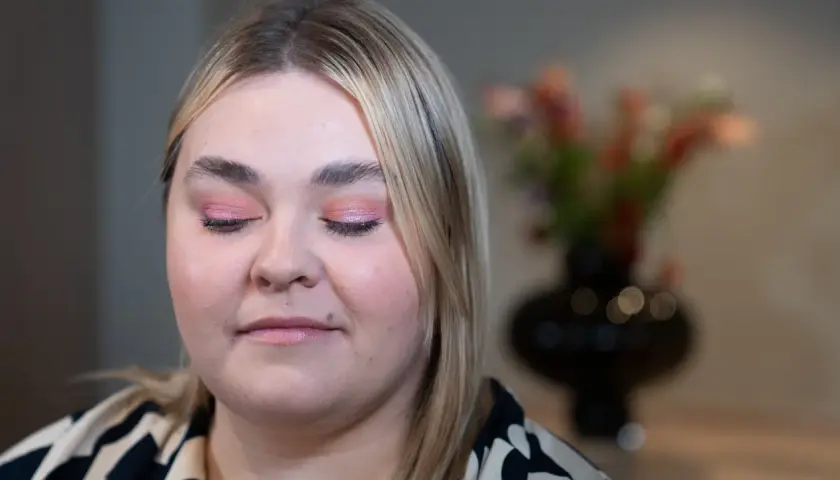En närbild på en kvinna med rosa skimrande ögonskugga på sina hooded eyes.