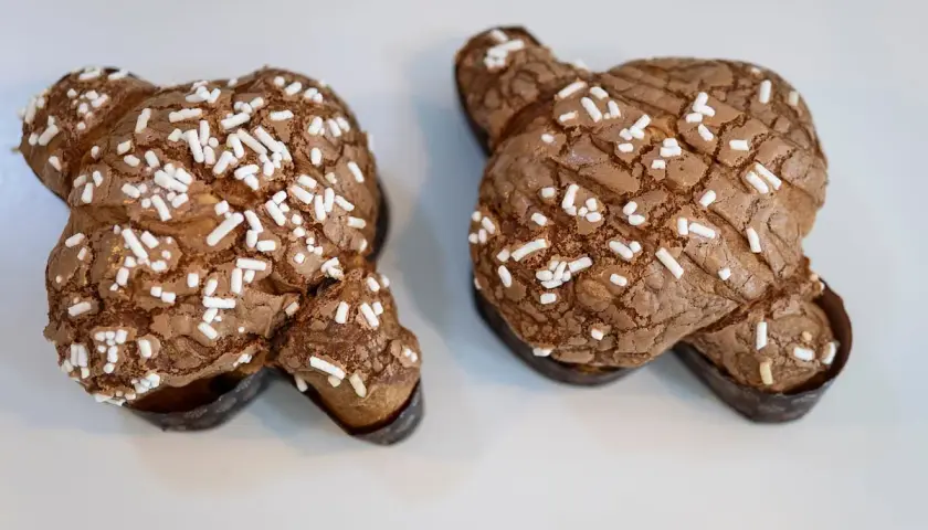 Dos deliciosas colomba de chocolate, cubiertas de azúcar perlado, listas para ser disfrutadas.