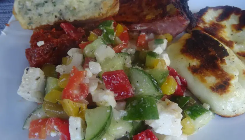 Frischer Paprika Gurken-Salat mit Feta, dazu gegrilltes Fleisch und Brot. Ein Genuss!
