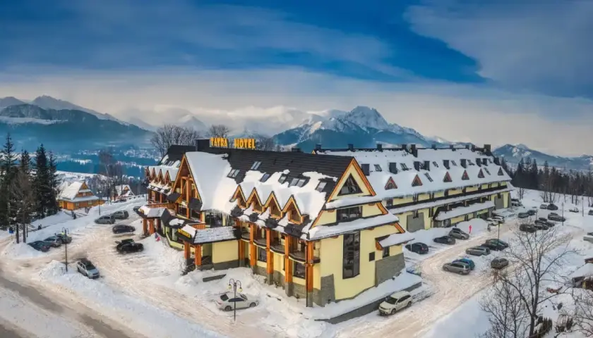 Zimowy krajobraz z hotelem w stylu góralskim. W tle majestatyczne Tatry. Idealne miejsce na wypoczynek, cyrhla zakopane.