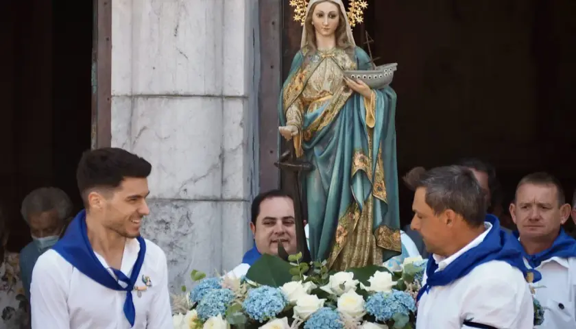 Procesión de la Virgen de la Guía, con hombres portando la imagen adornada con flores.