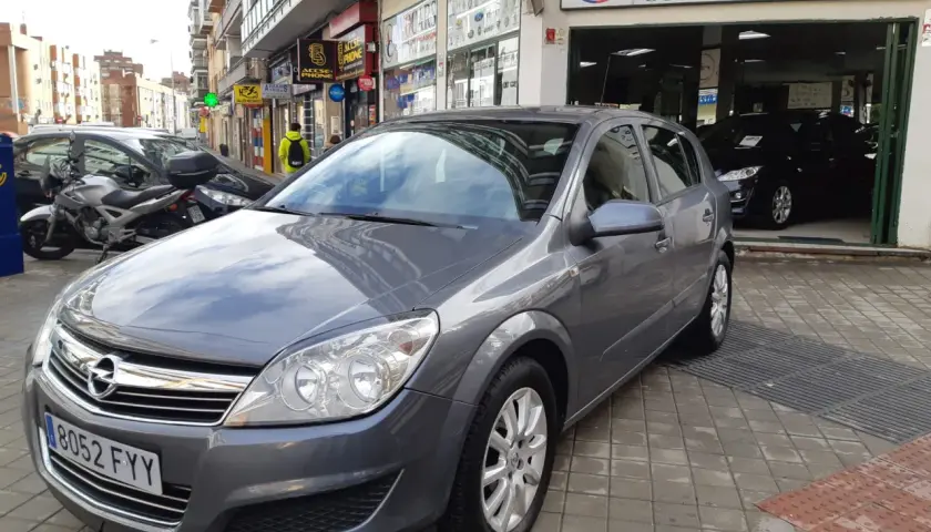 Opel Astra 1.7 CDTI 110CV gris aparcado frente a concesionario de coches de ocasión AVOCARS.