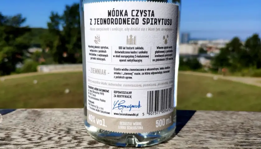 Etykieta butelki wódki czystej opisuje różnicę między wódką czystą zbożową a ziemniaczaną w smaku i aromacie, podkreślając ziemniaczaną jako aksamitną z nutą ziemniaka.