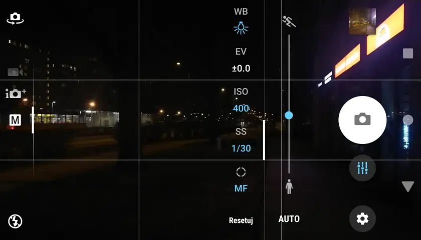 Ekran telefonu z widokiem nocnym. Ustawienia aparatu pokazują, jak ustawić długi czas naświetlania. Widoczny tryb manualny (M) i czas 1/30s.