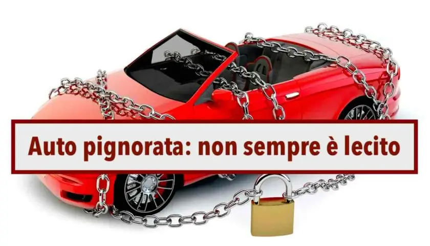 Auto rossa con catene e lucchetto, simbolo di pignoramento auto con finanziamento in corso.