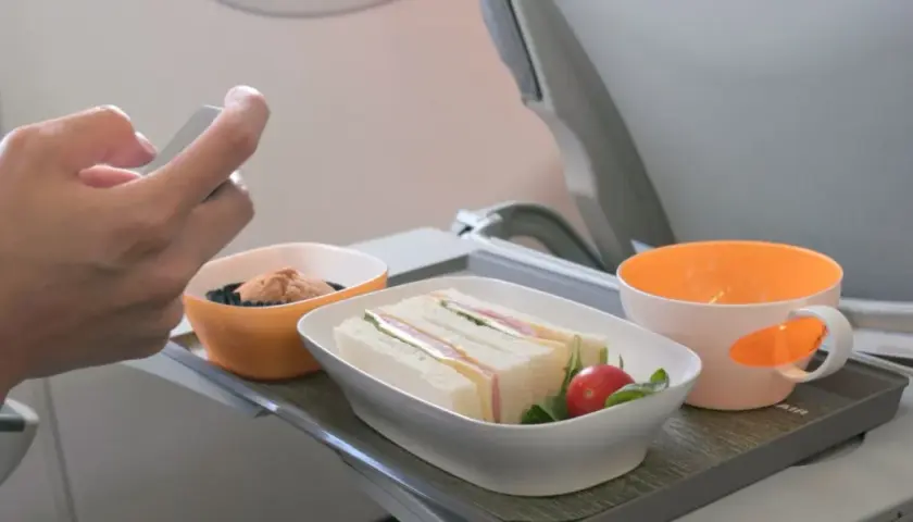 Na tacy w samolocie kanapki i deser. Czy w bagażu podręcznym można mieć jedzenie? Tak, jeśli jest to posiłek na pokładzie.