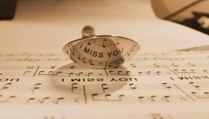 Un anillo con la frase "I MISS YOU" sobre partituras. Un detalle que evoca indirectas y frases de te echo de menos.