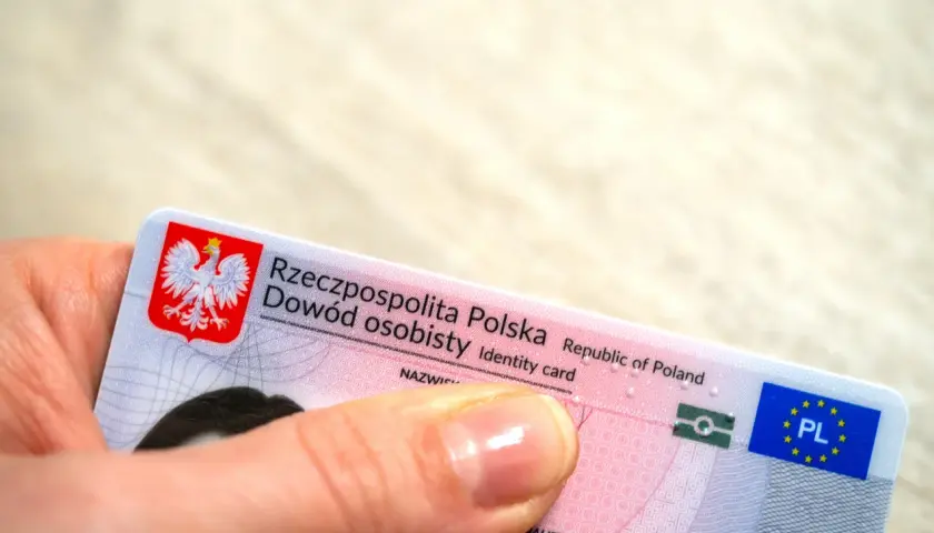 Dłoń trzyma polski dowód osobisty. Czy imię z bierzmowania jest w dowodzie? To pytanie nurtuje wielu Polaków.