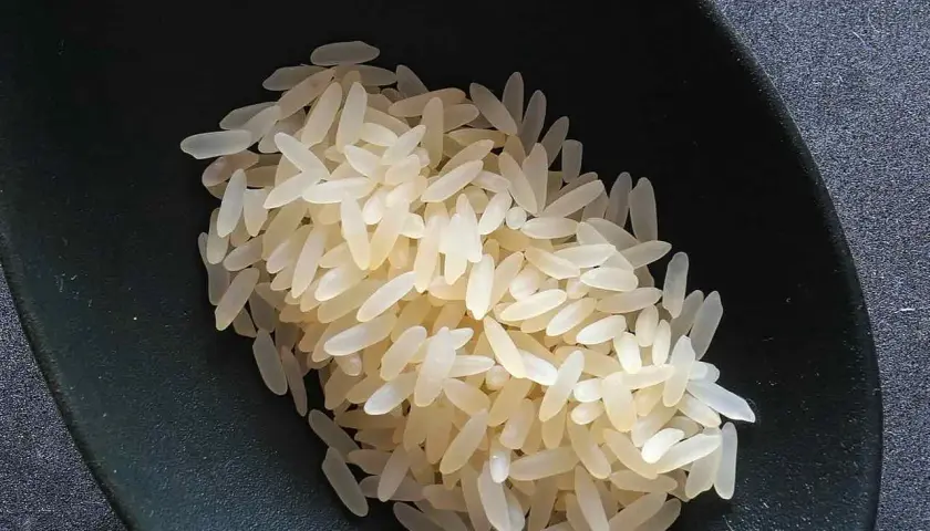Chicchi di riso originario pronti per la cottura, in una ciotola scura.