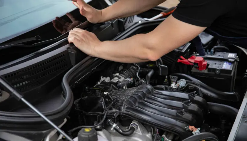 Mecánico revisando el motor PureTech. Las opiniones sobre su rendimiento y fiabilidad son variadas, pero su diseño compacto es notable.