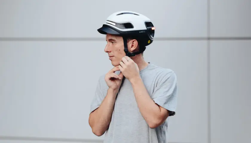 Uomo con casco bianco e nero, con luci LED integrate. Le misure del casco moto sono importanti per la sicurezza.