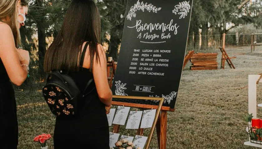 Cartel sobremesa de bienvenida a una boda con horarios y nombres de los novios.