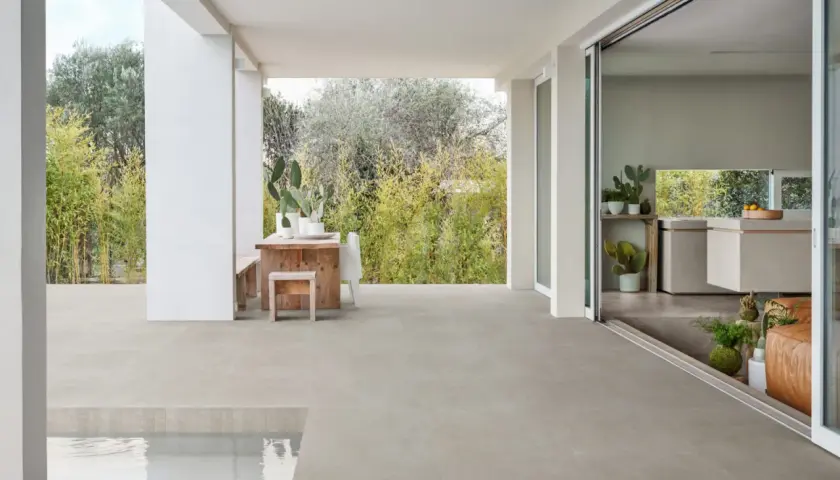 Terrazza con piscina e cucina moderna, pavimentata in gres materiale che si estende all'esterno.