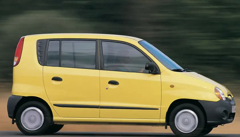 Żółty Hyundai Atos w ruchu, z rozmytym tłem sugerującym prędkość.
