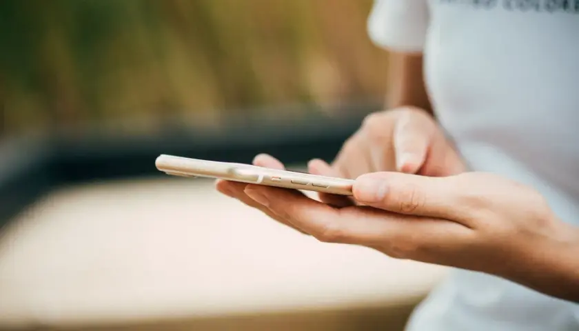 Mani che scorrono su uno smartphone dorato. Come in un ciclo, chi fa orbiting ritorna sempre a connettersi.