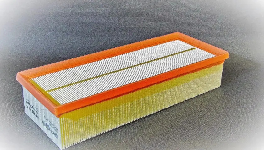 Filtro de aire rectangular con marco naranja y pliegues amarillos. Pregúntate cada cuanto se cambia filtro de aire para mantener tu motor limpio.