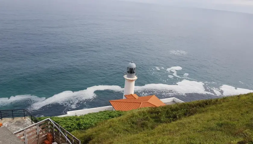 El faro del pescador en Santoña se alza vigilante sobre el mar Cantábrico, con espuma blanca adornando las olas.