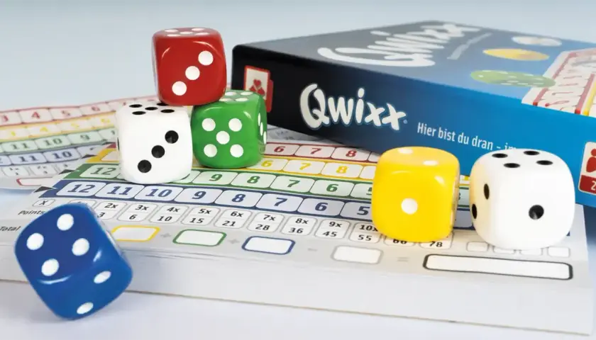 Bunte Würfel und Spielkarten für das beliebte Würfelspiel Qwixx. Hier sind die Rollen für spannende Runden bei den Brettspielen.