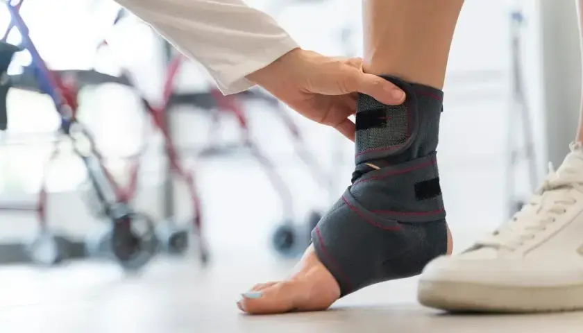 Fizjoterapeuta zakłada stabilizator na stopę pacjenta. Rezonans stopy może pomóc w diagnozie urazów.