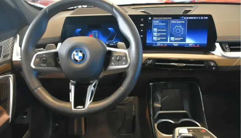 Wnętrze BMW X1 z nowoczesnym ekranem i kierownicą. Sprawdź aktualną bmw x1 cena i wyposażenie.