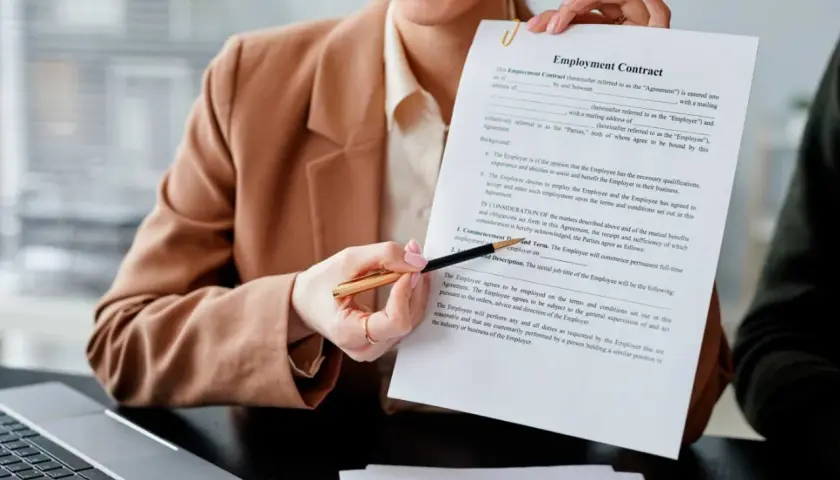 Persona sonriente muestra un contrato de empleo, lista para firmar contrato.