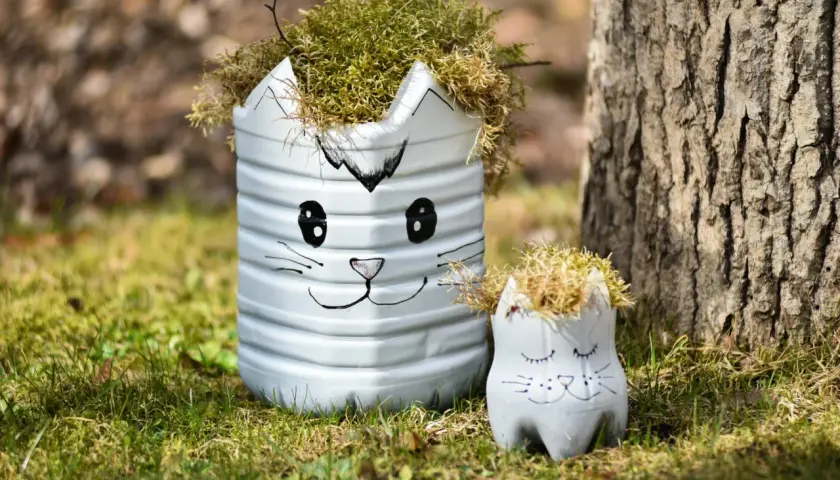 Urocze dekoracje ogrodu DIY w kształcie kotków, wykonane z recyklingu, dodają uroku zielonej trawie.