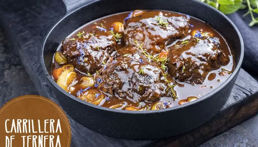 Carrilleras de ternera estofadas en salsa oscura, con trozos de verdura y hierbas. ¡Un clásico de la receta de la abuela!