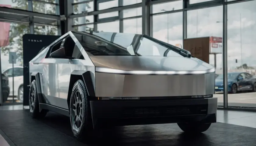 Futurystyczny Cybertruck Tesli prezentuje swoje ostre linie i metaliczne nadwozie w salonie.