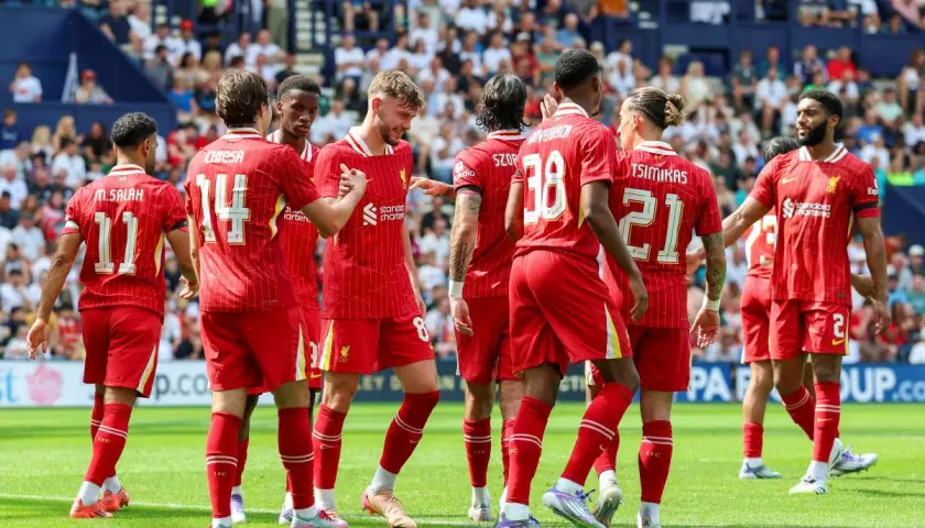Piłkarze Liverpoolu, mistrzowie Anglii, świętują na boisku. Widać numery 11, 14, 8, 38, 21 i 2.
